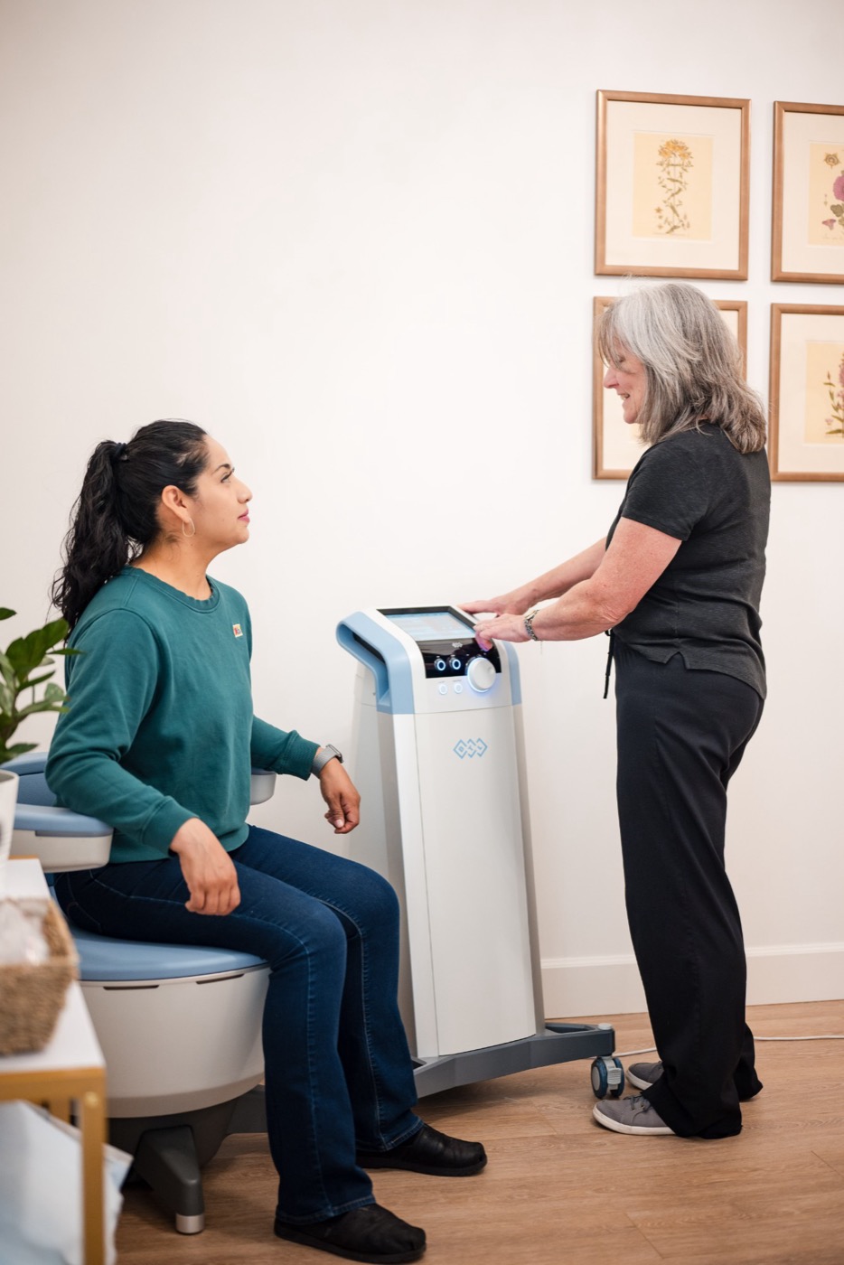 A Swiftwater nurse starting an Emsella session while the patient sits fully clothed in the chair