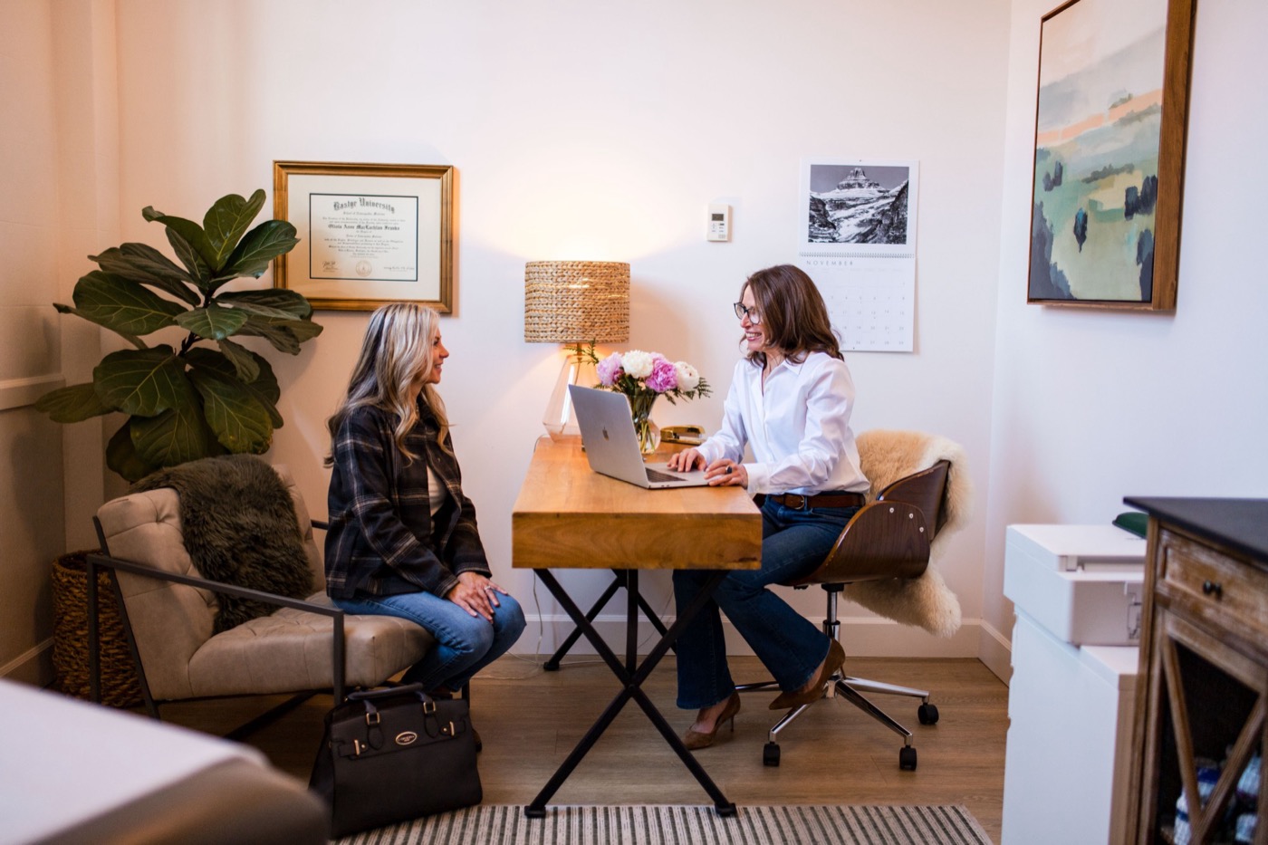 Dr. Olivia Franks smiling with a patient during a consultation at her desk